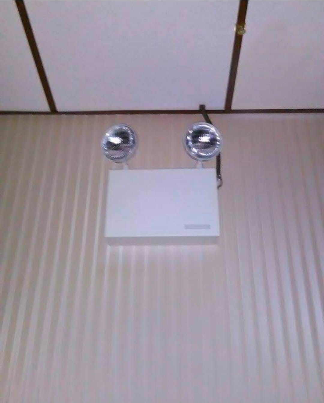 Emergency lighting unit installed on a commercial ceiling